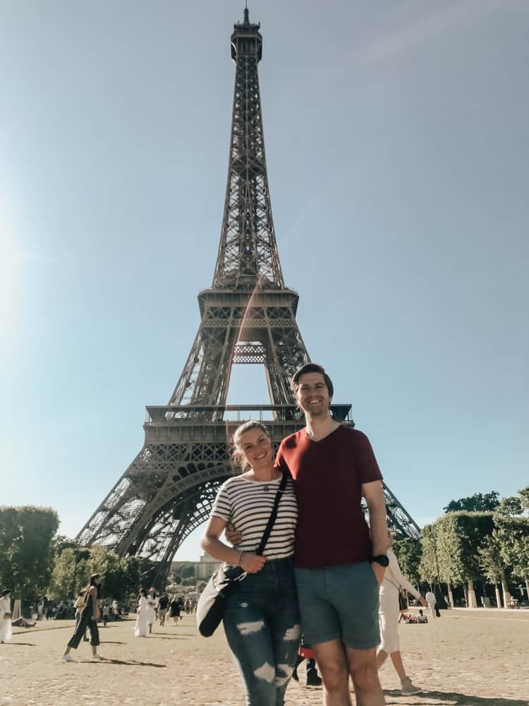 Kat and Chris standing in front of the Eiffel Tower in Paris