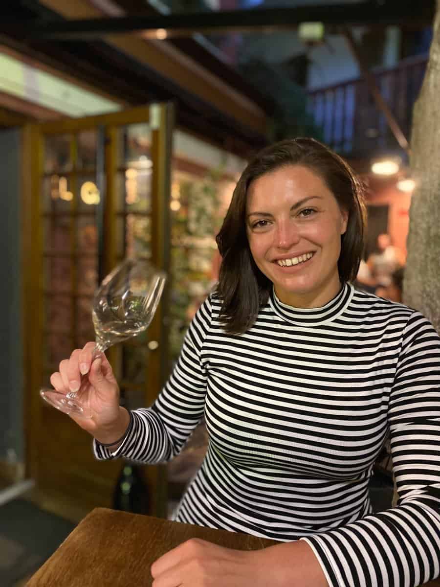 Kat with a glass of wine at a wine bar in Annecy