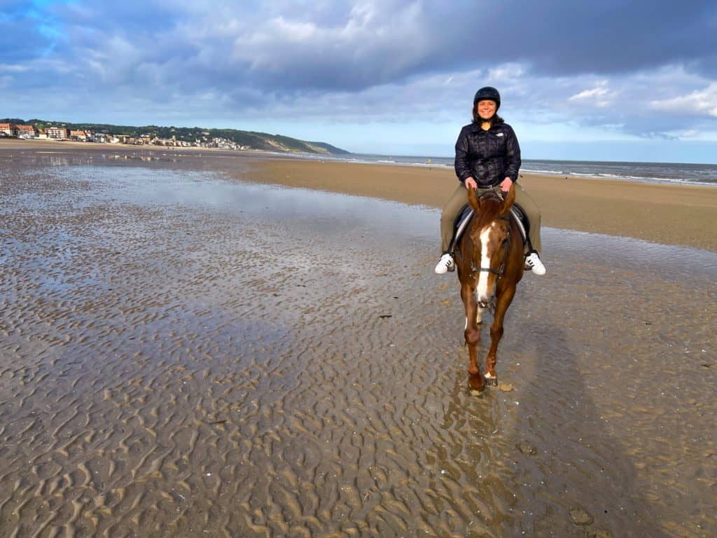 Kat riding a horse on the beach near Deauville