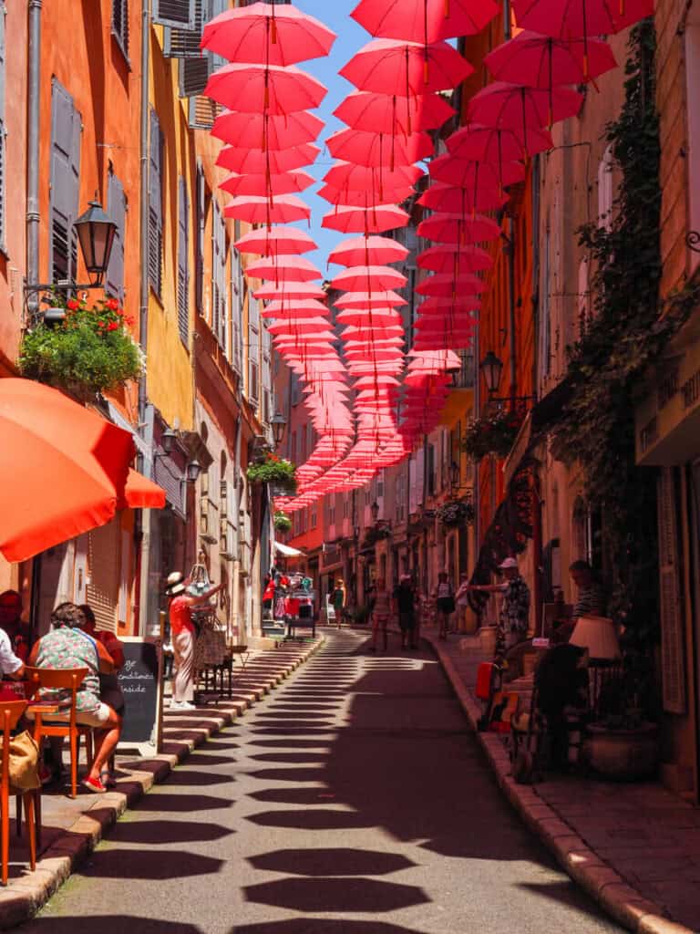 Colorful street with pink umbrellas