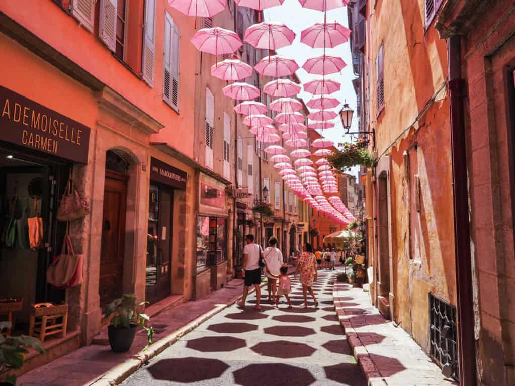 Street with shops and pink umbrellas