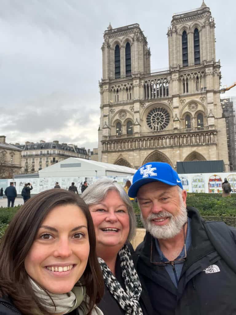 Kat and her parents smiling with Notre Dame in the background