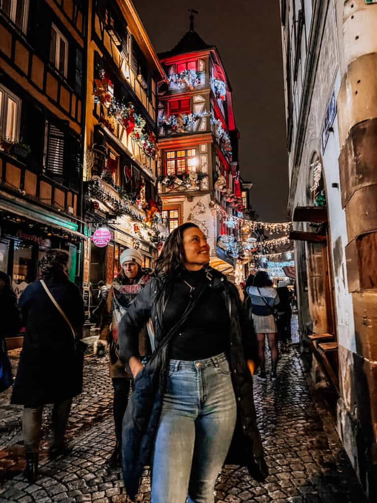 Kat posing in Strasbourg with Christmas decor in background