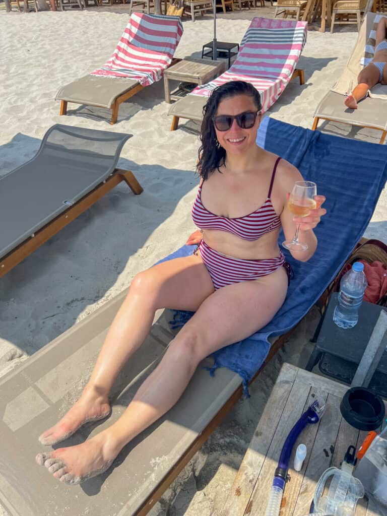 Kat with a glass of white wine at Playa Baggia beach club in Corsica