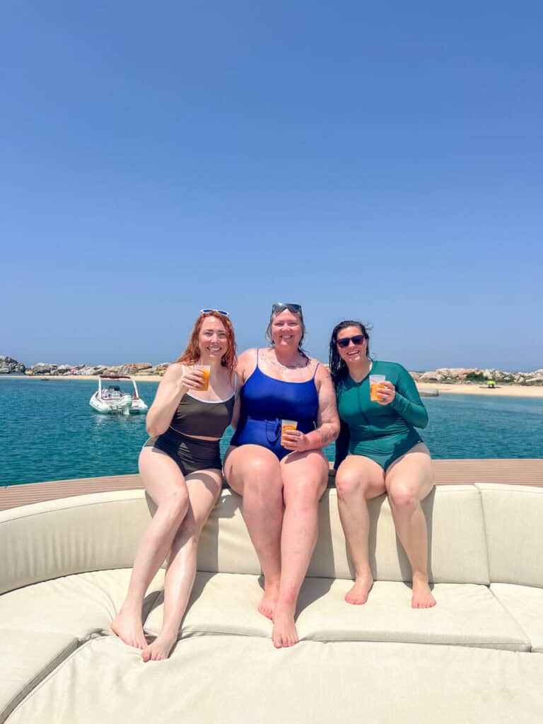 Megan, Sara, and Kat with drinks on a boat crusing the Lavezzi islands