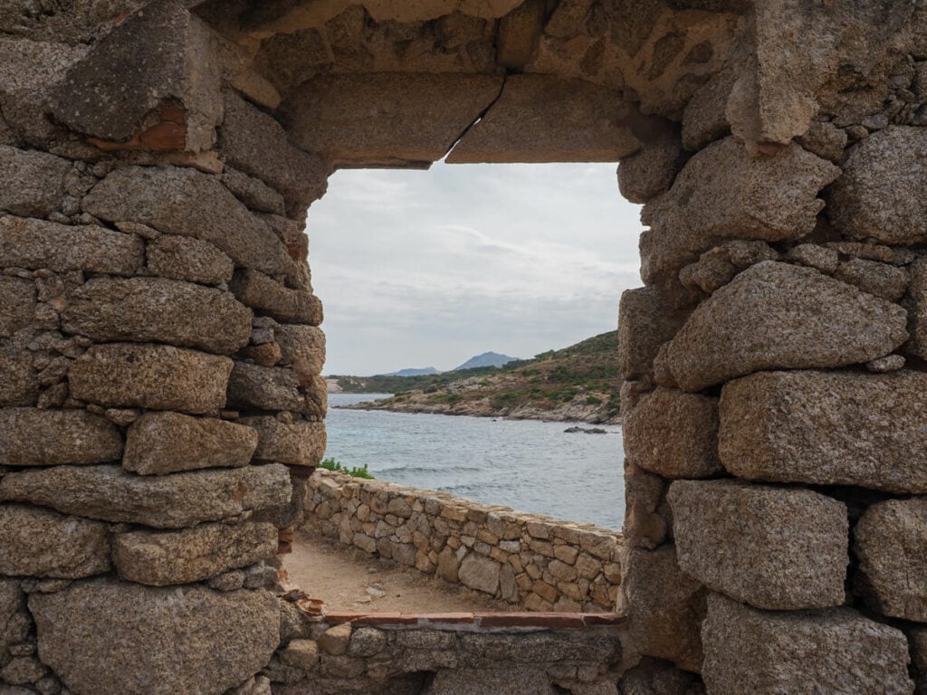 Views of the land and sea from a window of a stone building on the Pointe de la Revellata hike