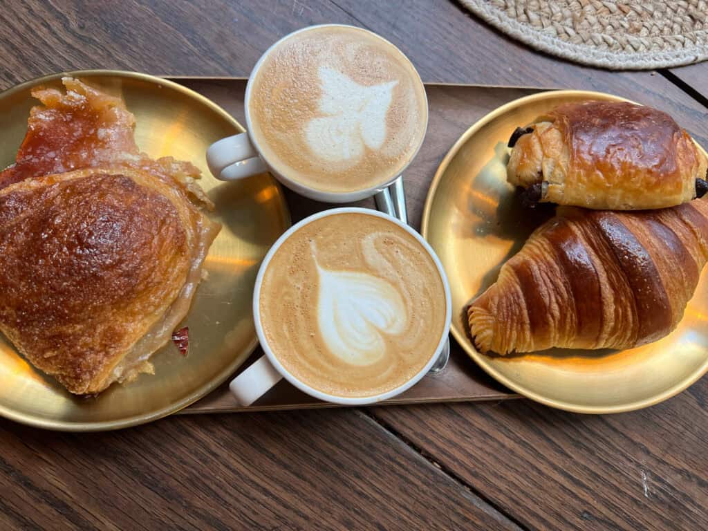 Sain Boulangerie lattes, pain au chocolat, chausson aux pommes, and croissant