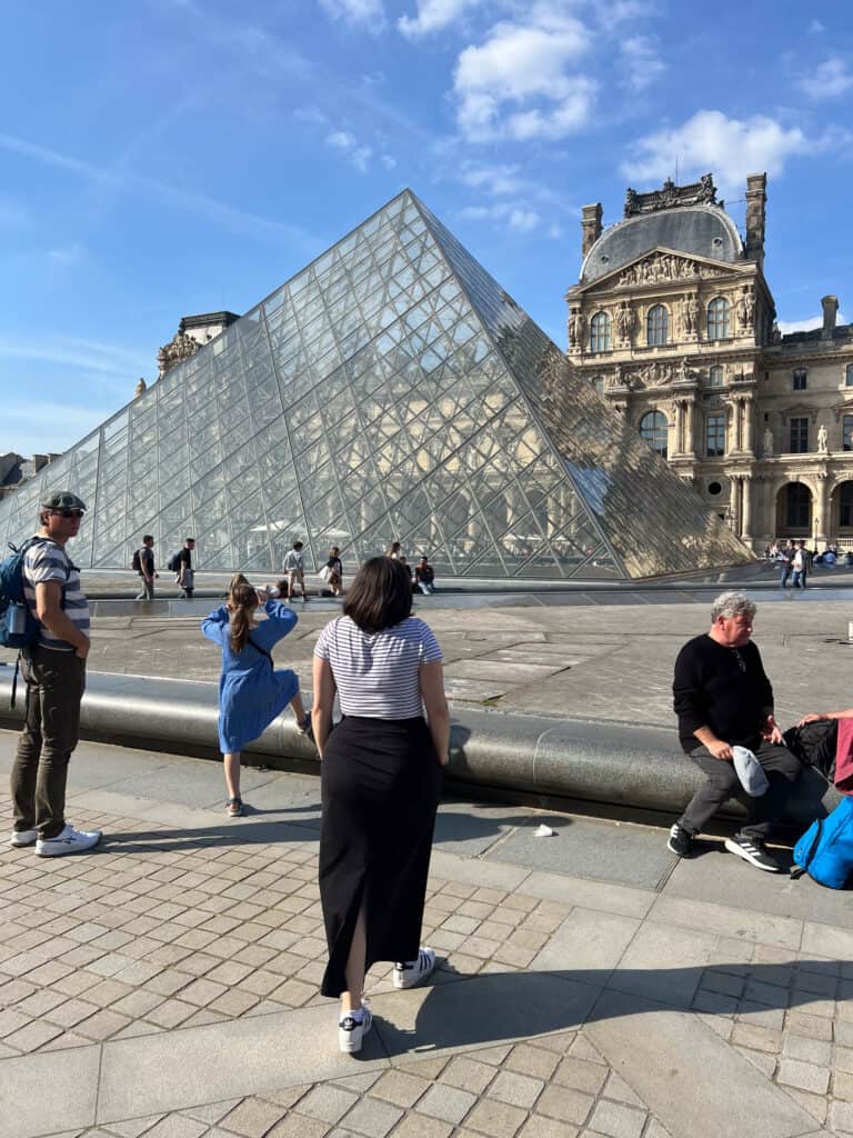 Kat walking toward the Louvre pyramid