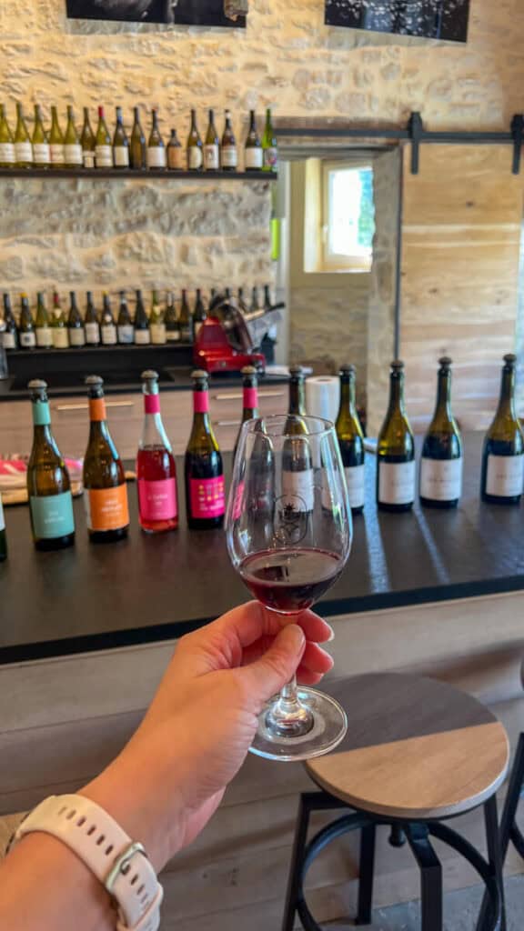 glass of wine in front of wine bottles at Mas del Perie